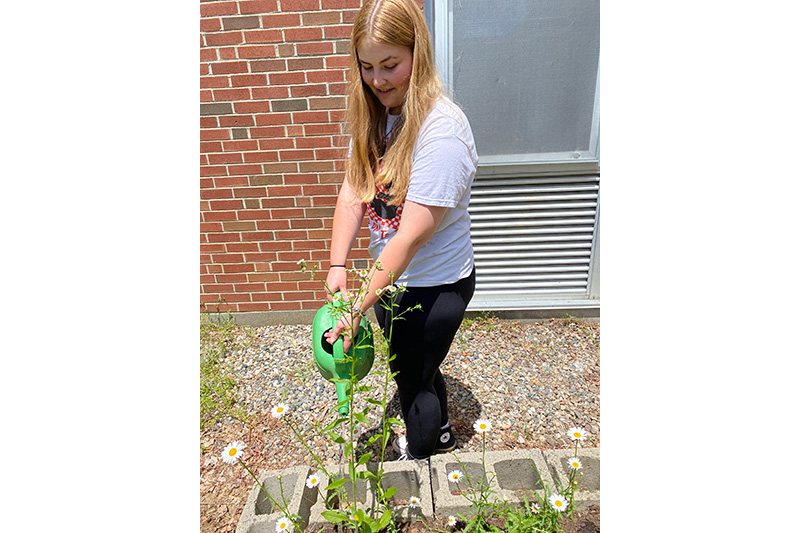 Female student watering flowers